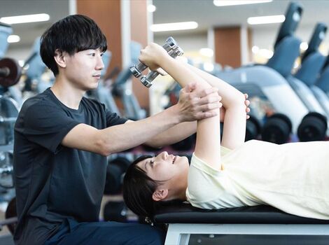 トレーニングの指導をする男性スタッフ_R